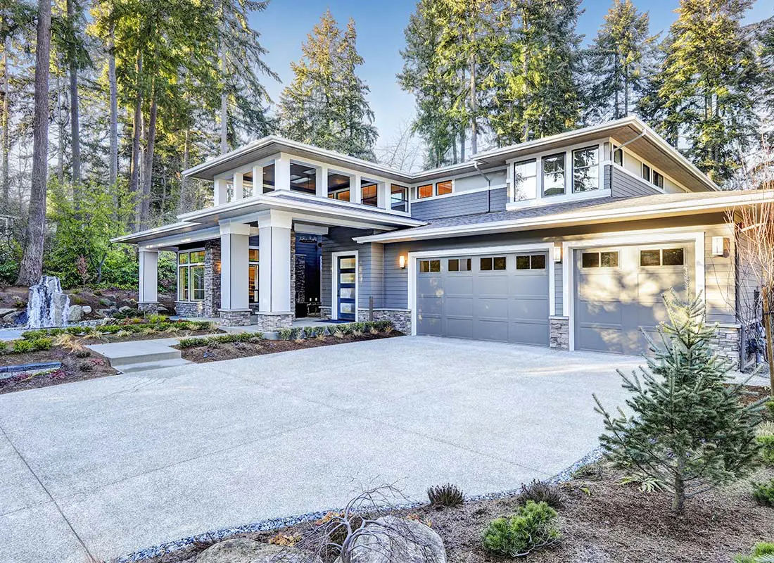 High-Net-Worth-Insurance-Luxurious-New-Construction-of-Home-With-Lots-of-Windows-in-a-Scenic-Wooded-Area-and-Large-Driveway