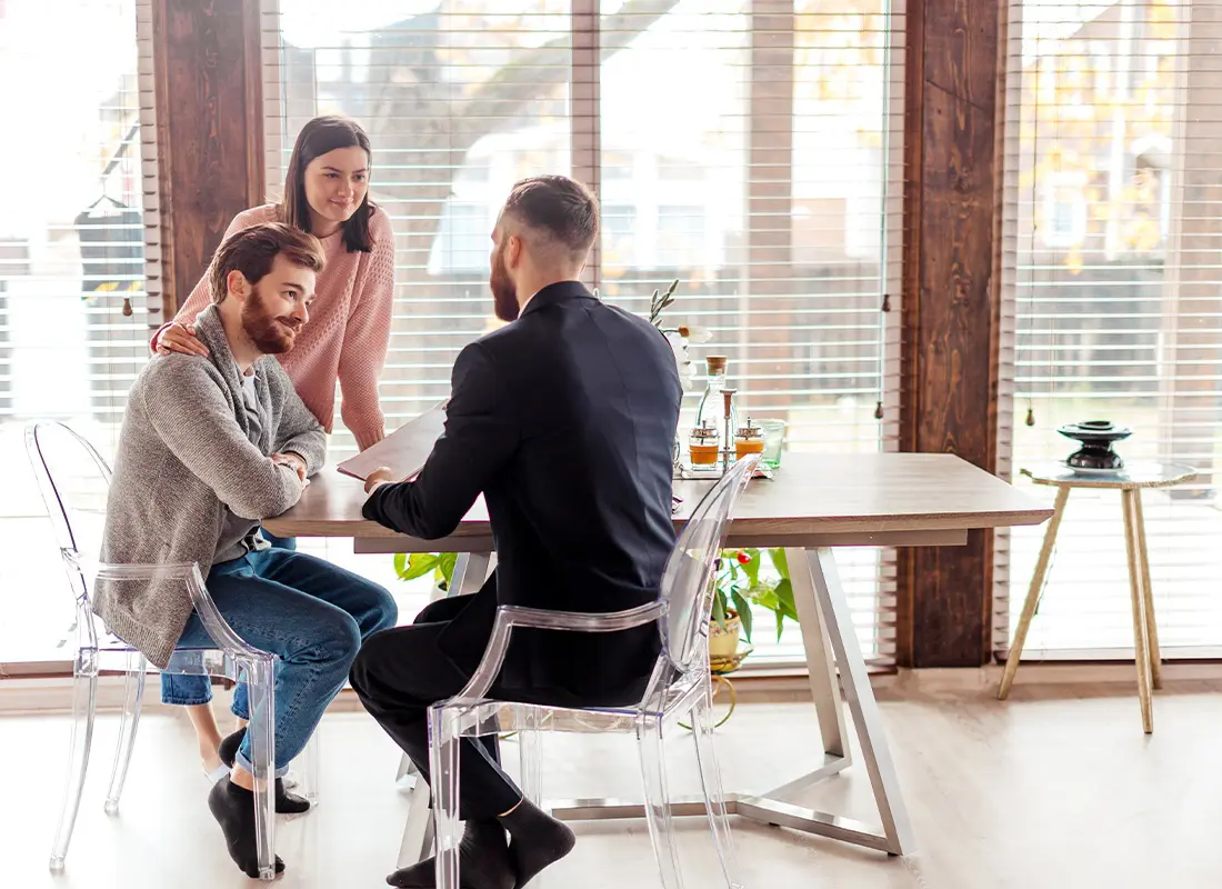 Home-Warranty-Protection-Couple-Meeting-With-a-Home-Warranty-Advisor-in-Their-Home-While-Sitting-at-Their-Kitchen-Table
