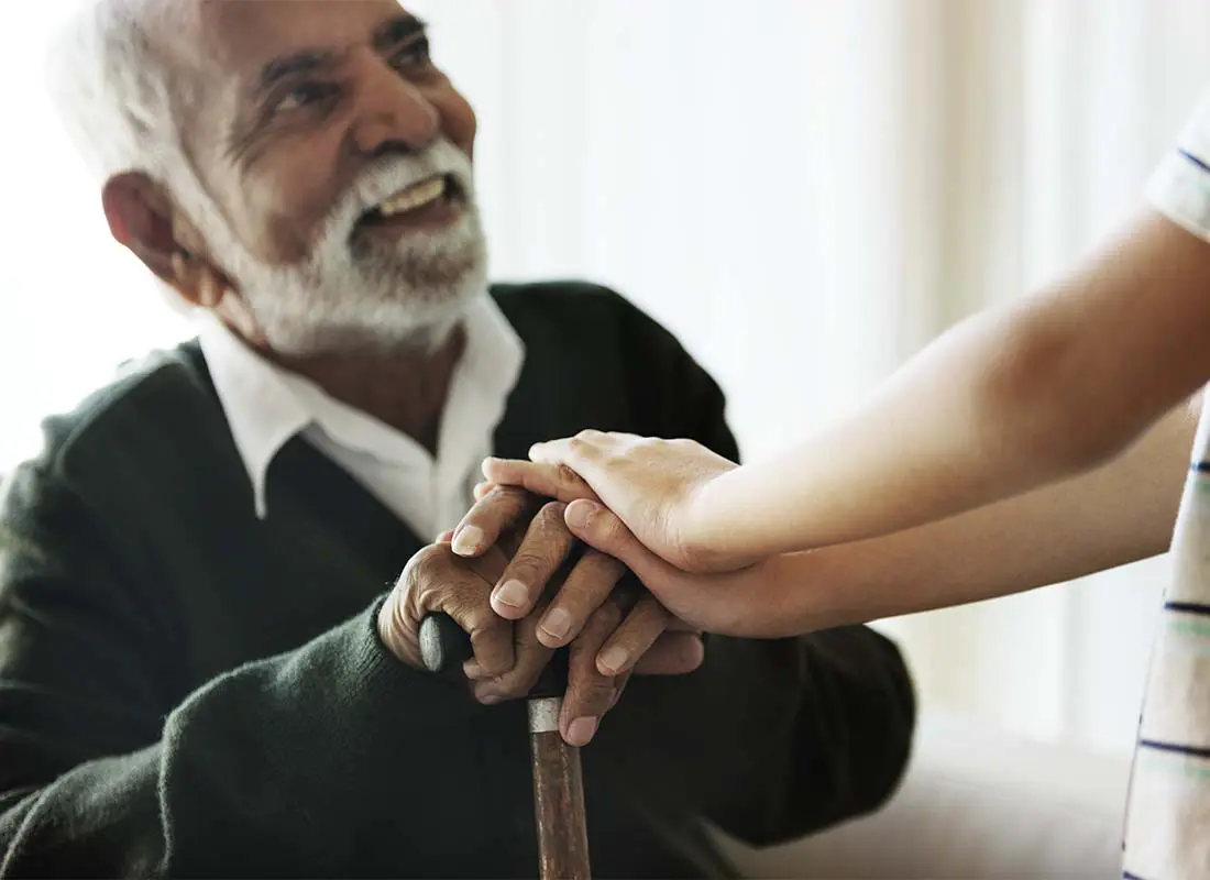 Long-Term-Care-Insurance-Senior-Man-Close-up-While-Sitting-and-Talking-with-His-Relative-during-a-Visit-to-His-Residence-at-a-Senior-Care-Facility-