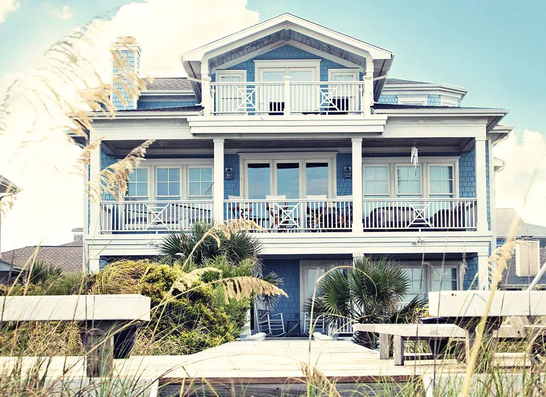 Secondary-Home-Insurance-Luxury-Beach-Front-Vacation-Home-with-Multiple-Balconies-and-Private-Dock-in-the-Summer-at-Dusk